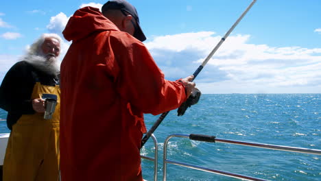 dos pescadores pescando desde el barco