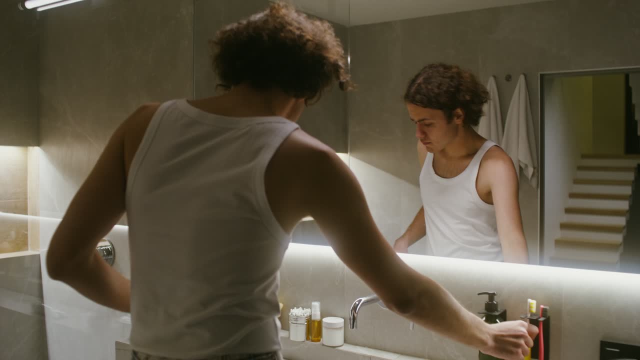 Uomo che si lava i denti in bagno