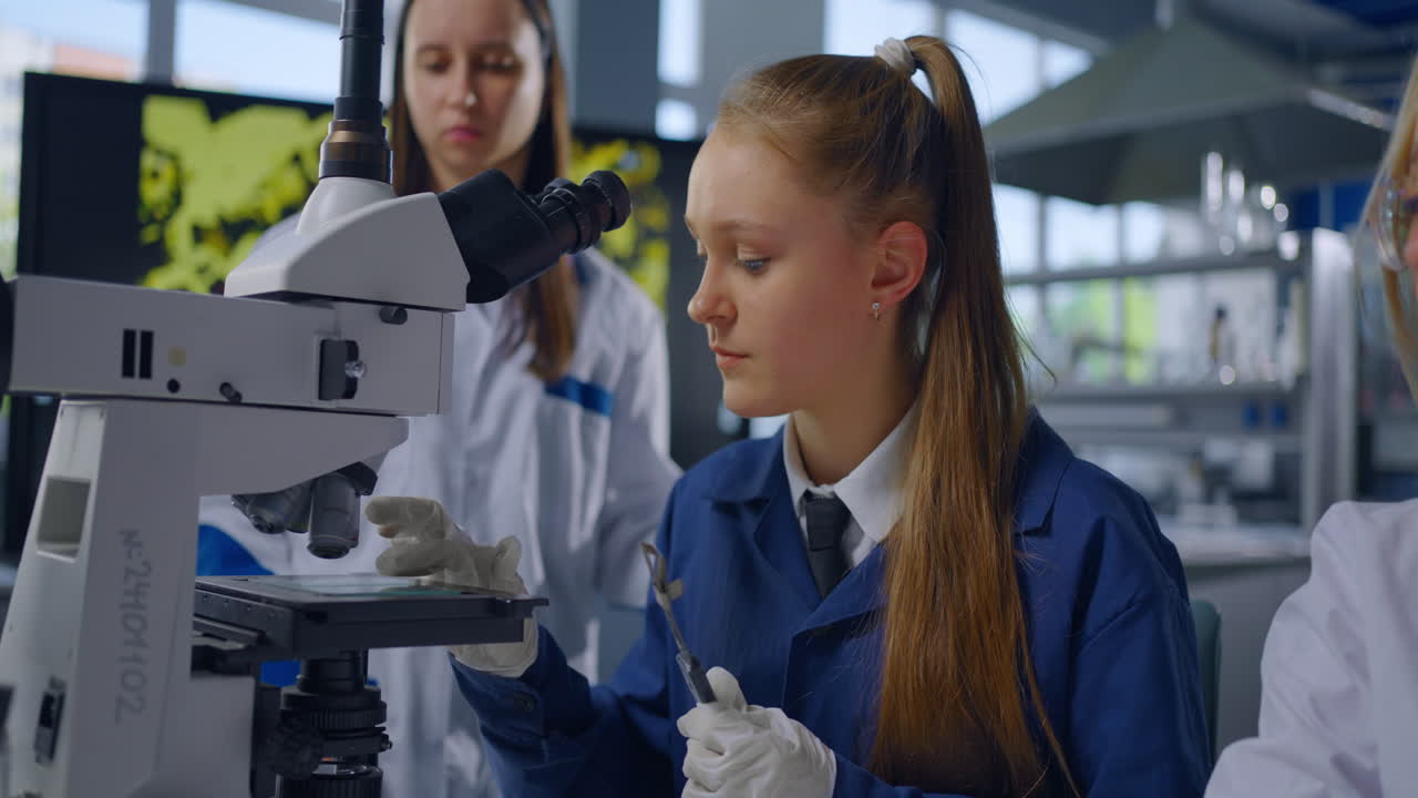 estudiantes usando un microscopio en un laboratorio