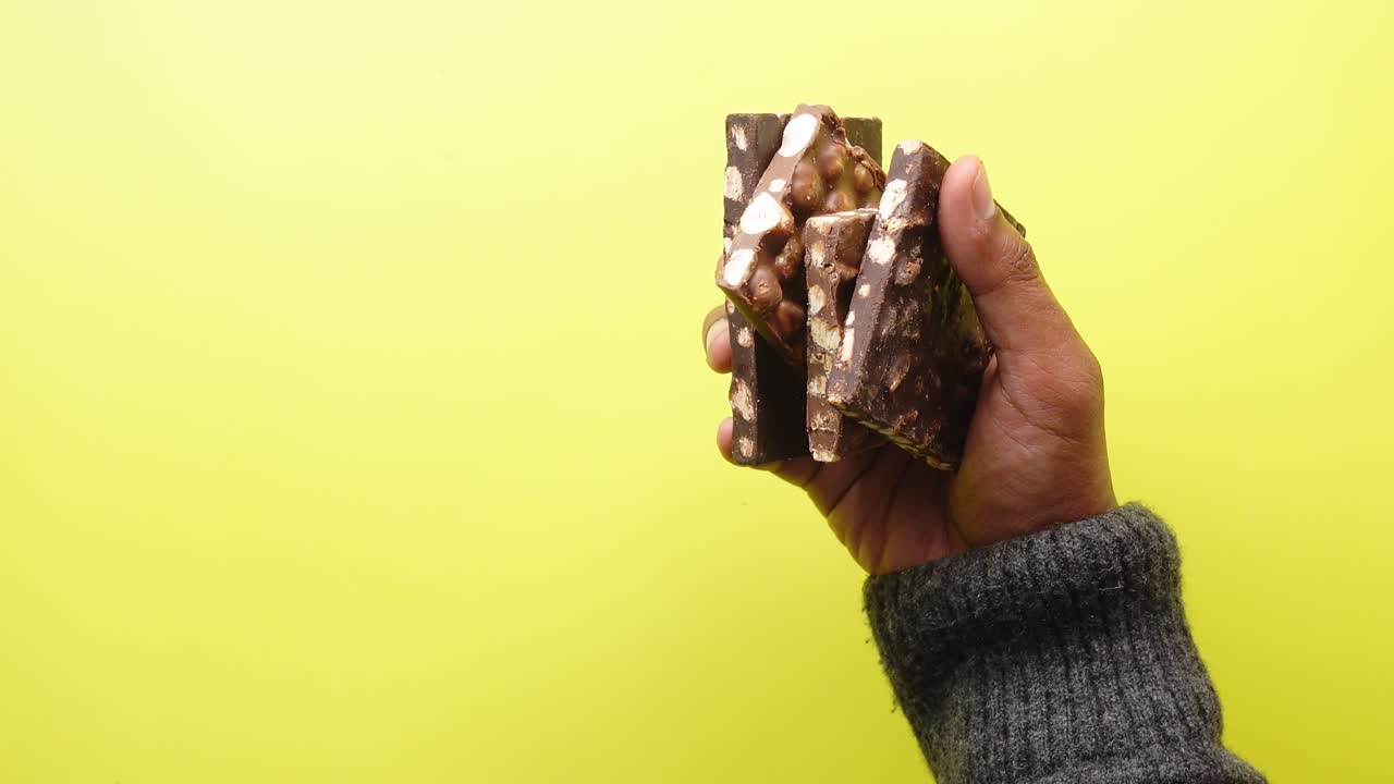 la mano sosteniendo barras de chocolate con avellanas