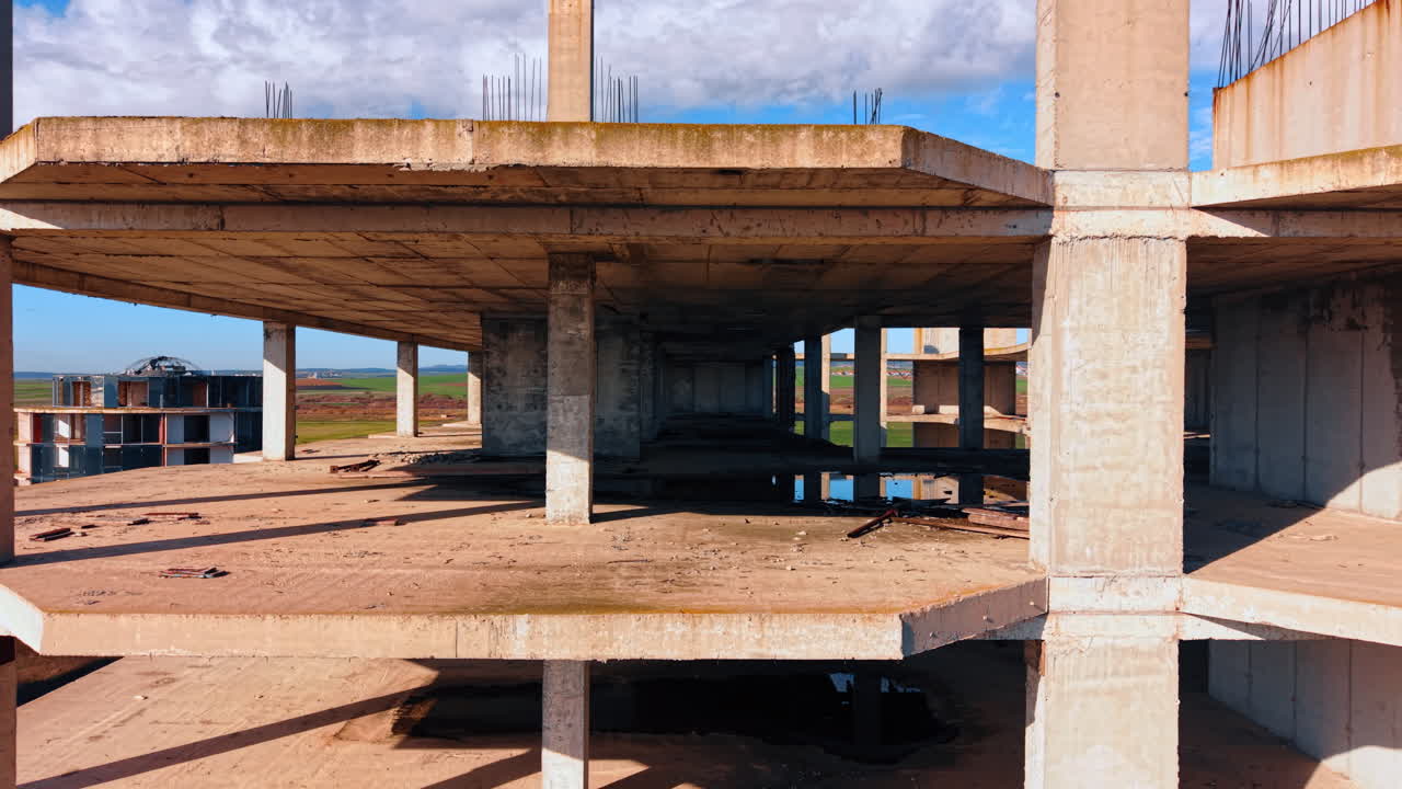 Abandoned construction of the multi-storied building. Drone footage along the floors of the structure