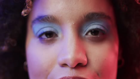 biracial woman with dark hair in blue and pink light, slow motion