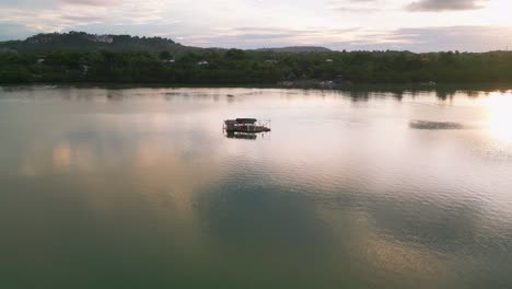 Vista-Aérea-Del-Complejo-De-Cabañas-Flotantes-En-La-Tranquila-Bahía-Durante-La-Puesta-De-Sol,-Filipinas