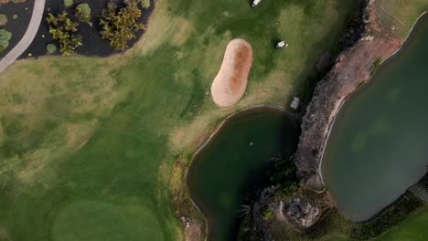 top down view of green golf course with large pond in center, tenerife spain