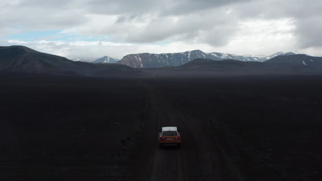 Drone-view-car-driving-offroad-path-on-Skaftafell-national-park-exploring-wilderness-of-Lakagigar-black-volcanic-desert.-Aerial-view-amazing-icelandic-panorama-with-snowy-high-mountains-peak
