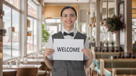 happy indian woman waiter holding welcome banner