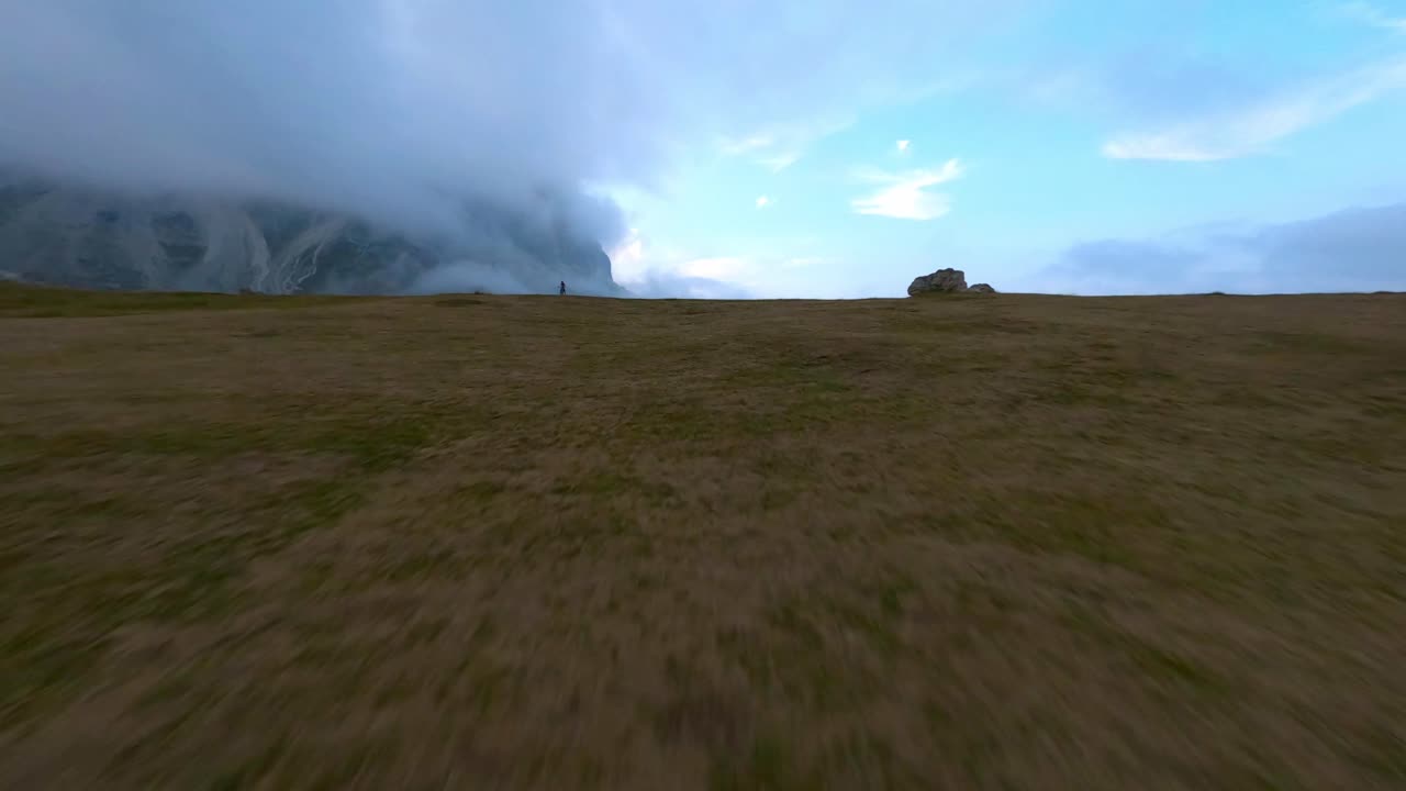seguimiento de vuelo fpv aéreo extremo ciclista de montaña conduciendo cuesta abajo hacia el valle de las montañas dolomitas
