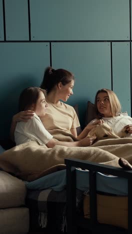 friends enjoying time together in bed with a dog
