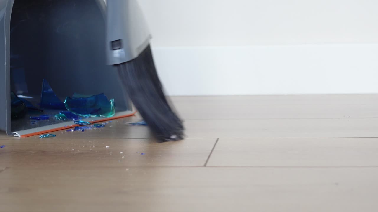 나무 바닥 의 깨진 유리 를 청소 하는 것
