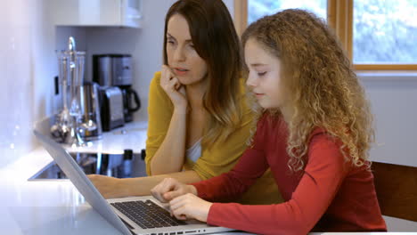 woman is teaching use the computer to her daughter