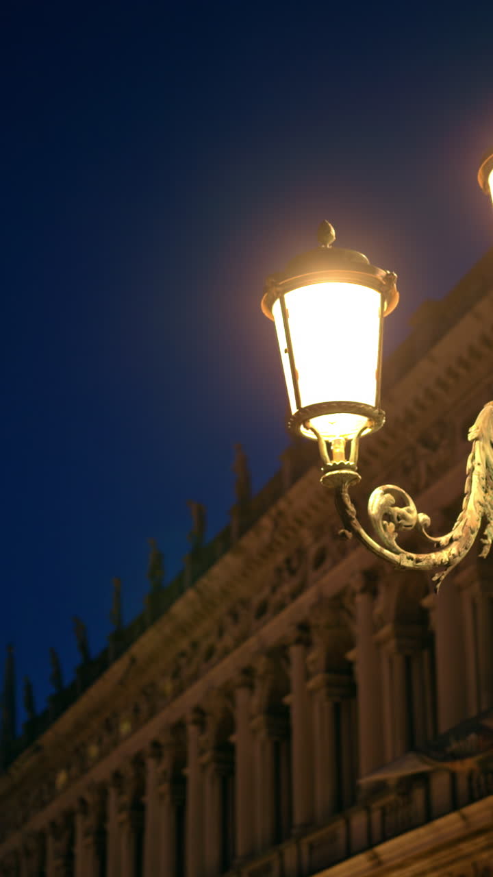 Close up of lighted street lamps in the evening in Venice, Italy. Vertical