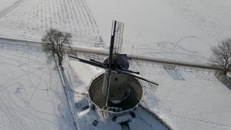 jib up of traditional windmill in rural snow covered landscape