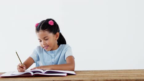 una colegiala sonriente haciendo su tarea