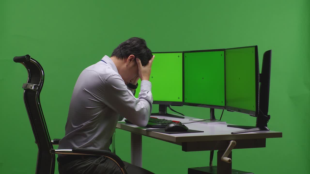Stressed Employee at a Multi-Monitor Workstation