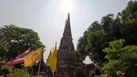 people carrying flags by ancient temple pagodas