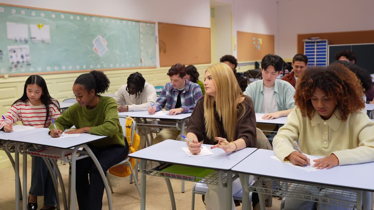 Grupo diversificado de alunos escrevendo em uma sala de aula