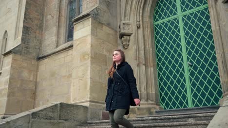 woman leaving church building by front stairs