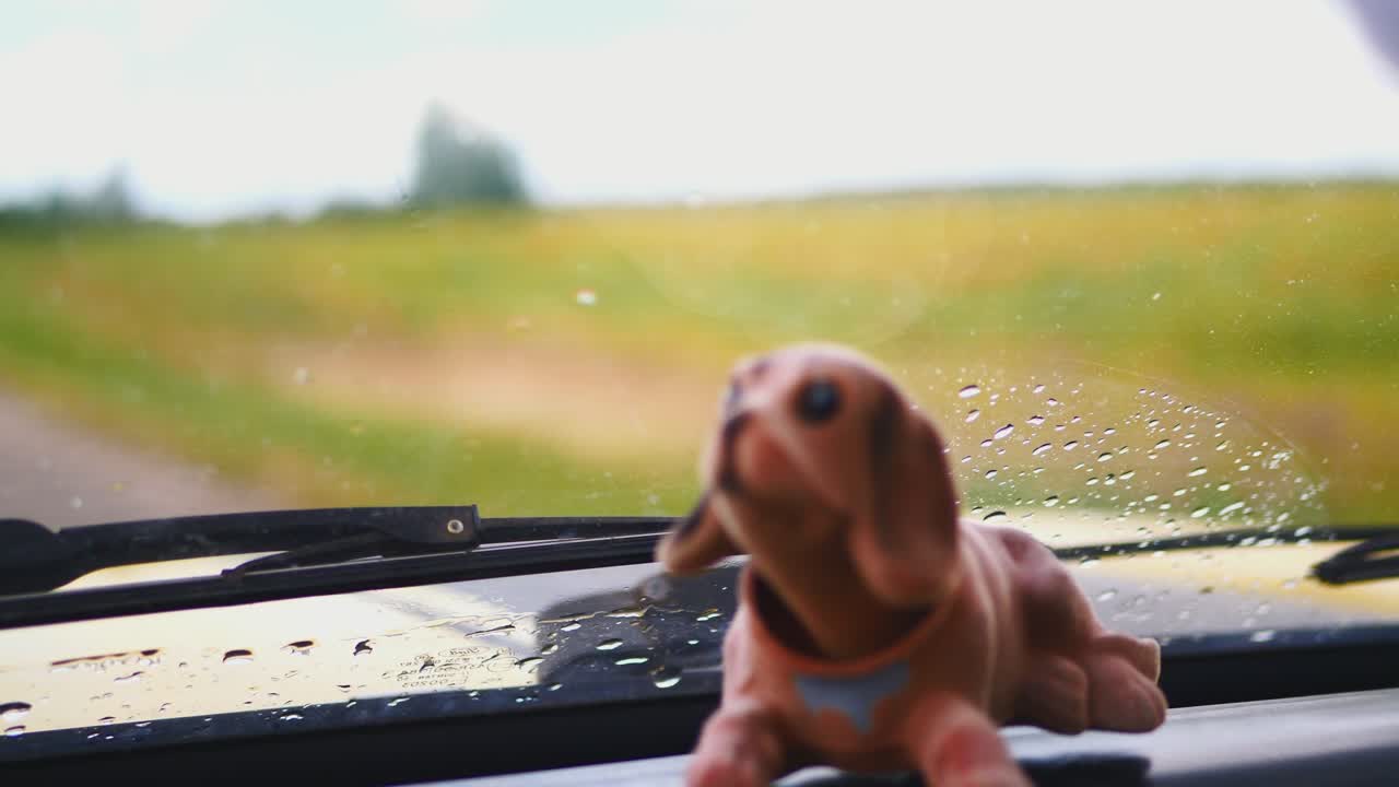 기념품 강아지 가 고전 자동차 의 패널 에 머리 를 매달고 있다