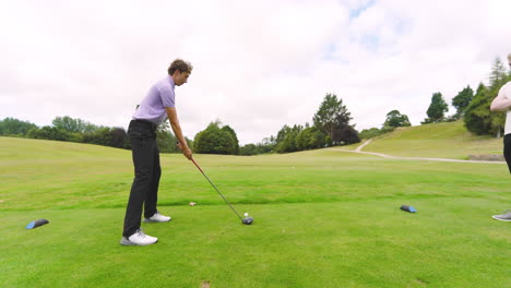 male golf players playing golf, one player knocks golf ball out on golf course, copy space