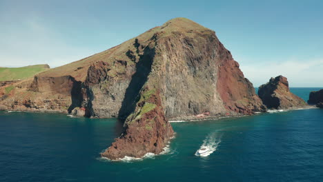 espectacular costa volcánica de madeira con barco explorando acantilados rocosos