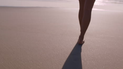 close up woman feet walking barefoot on beach at sunset leaving footprints in sand female tourist on summer vacation