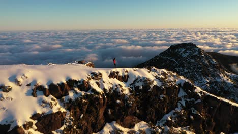 Mujer-De-Pie-Sola-Disfrutando-Del-Paisaje-épico-Desde-La-Cima-De-La-Montaña-Pico-Ruivo-En-Madeira-Con-Un-Lecho-De-Nubes-Detrás-De-Ella