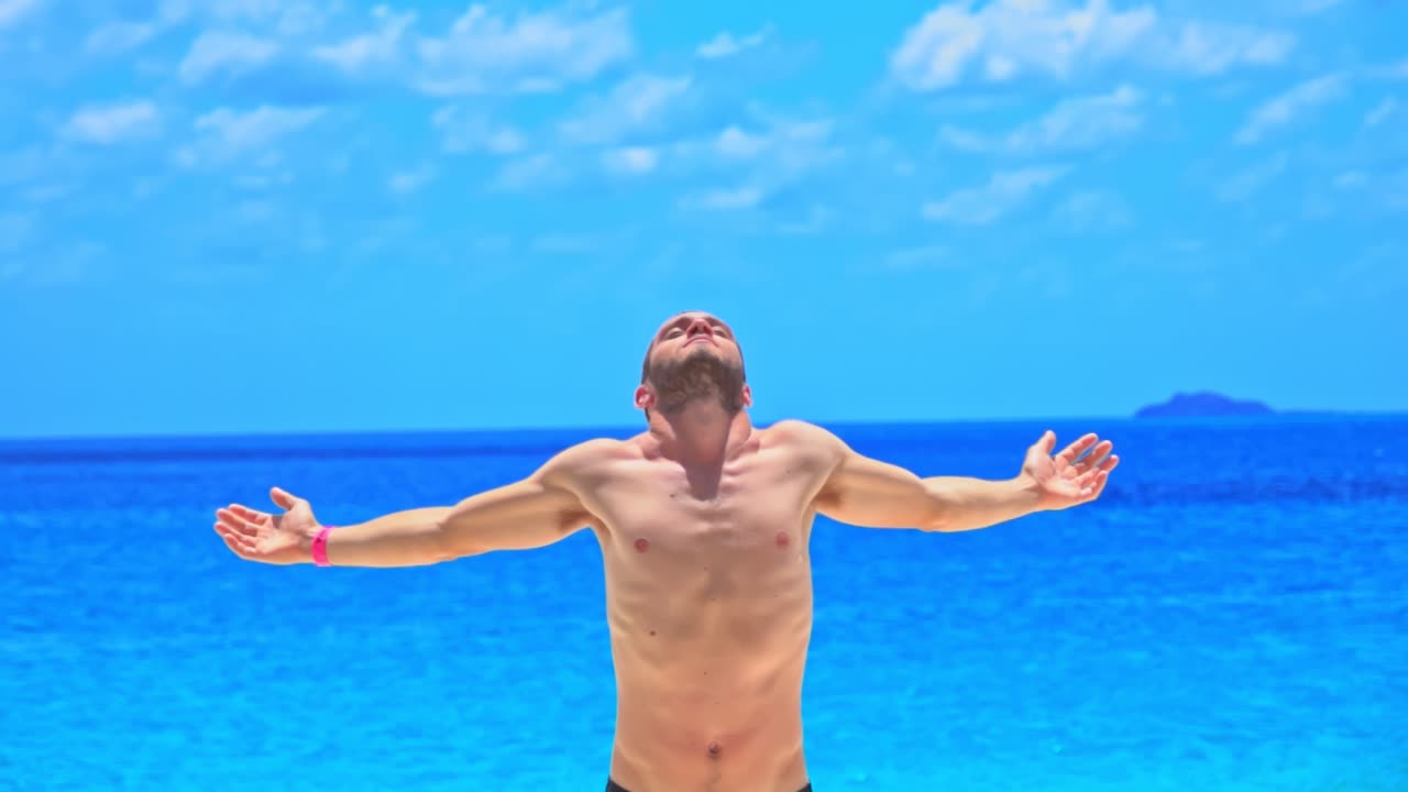 el hombre abre los brazos en libertad frente a un mar azul