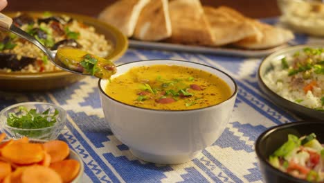 eating bean soup on table close-up. arabian cuisine. pita and bulgur, couscous on background. traditional middle eastern culture. delicious rice with meat. homemade food concept