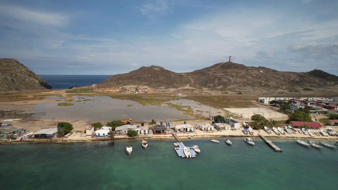 Isola Gran Roque che mostra acque turchesi, un piccolo porto e il paesaggio costiero, vista aerea