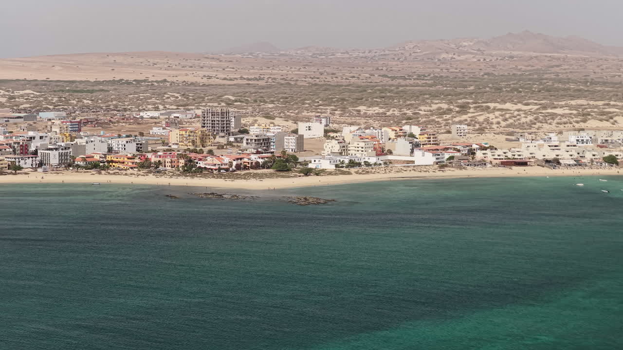 Drone shot of the city of Sal Rei, Old city with many colorful house, turquoise ocean and sandy beach, background the desert,Boa Vista, Cape Verde
