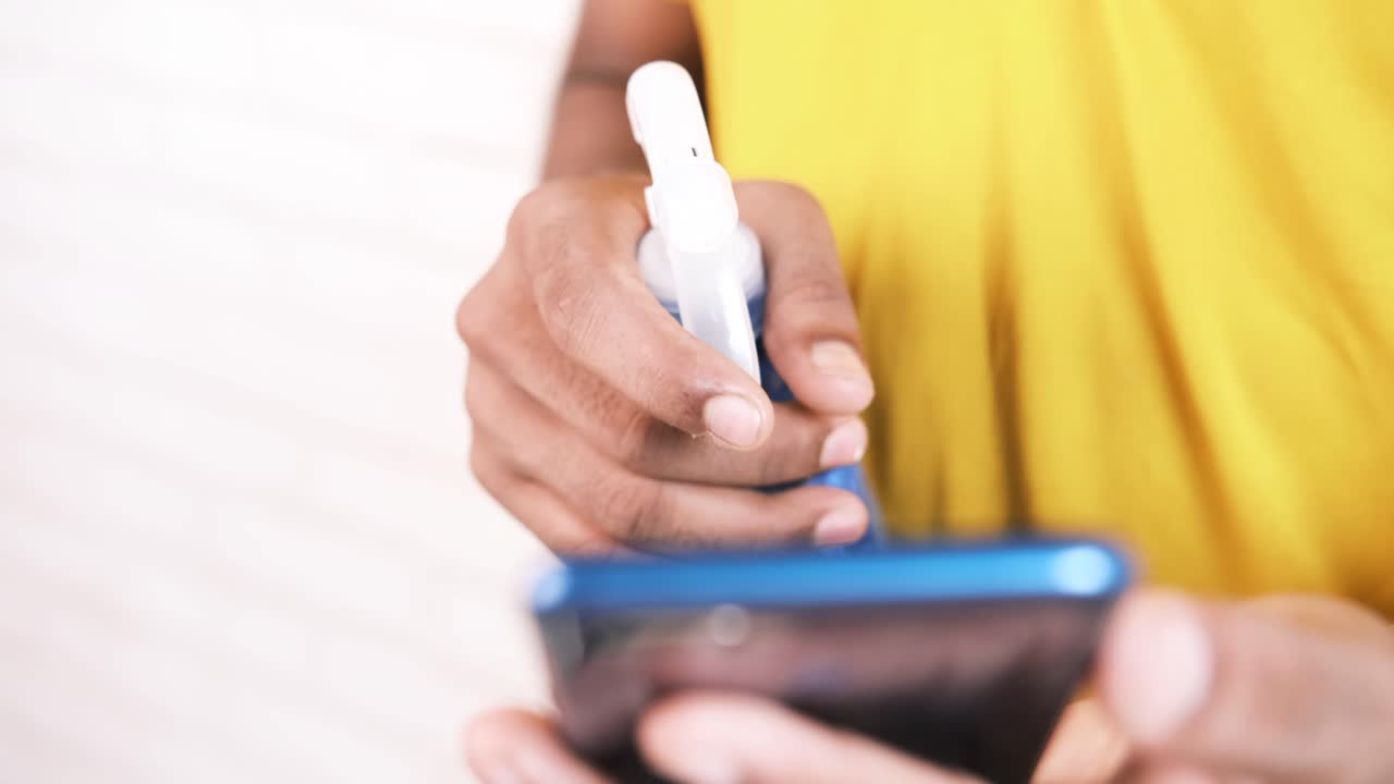 persona con una botella de spray y un teléfono