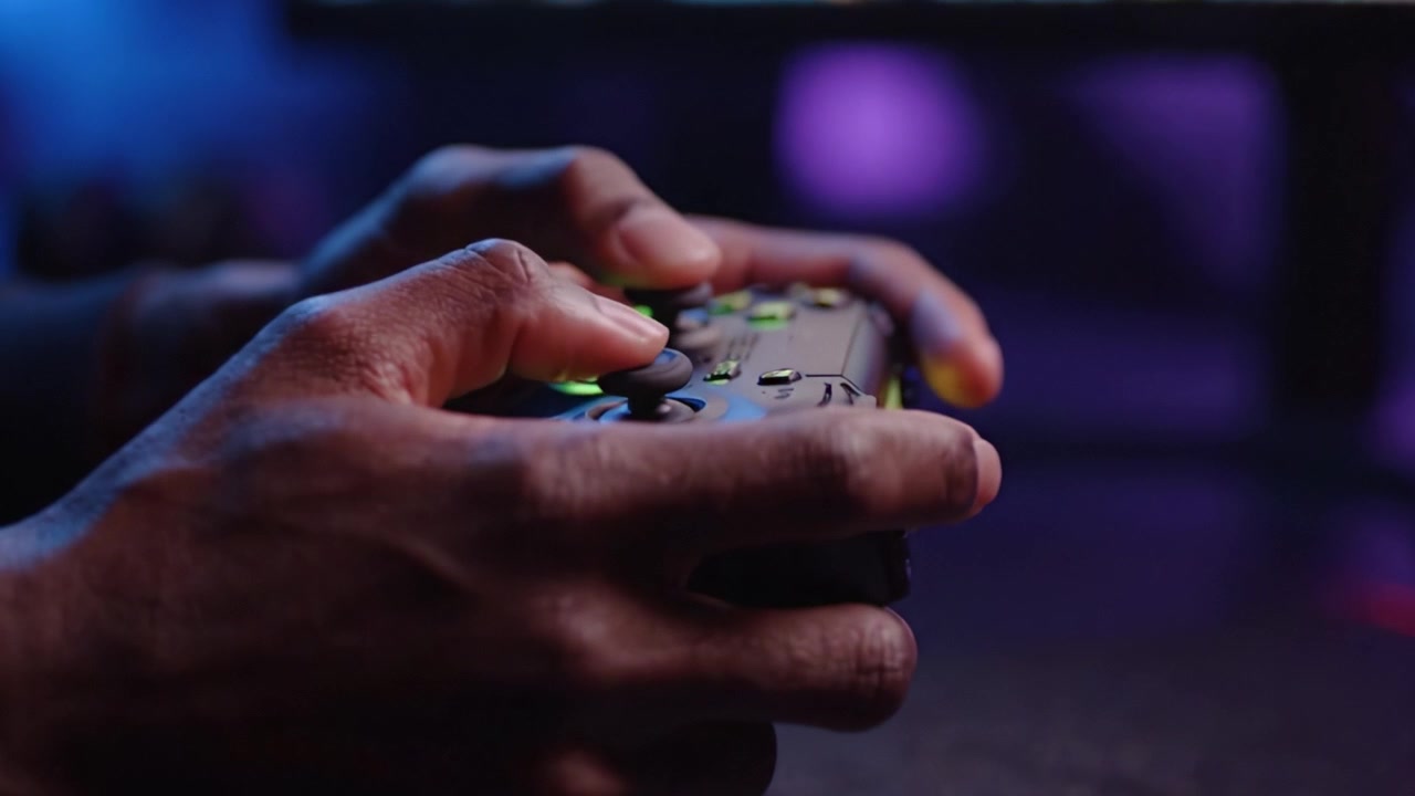 Dynamic Moments in Gaming: Capturing the Intensity of Gameplay with a Close-Up of Hands Gripping a Controller Under Colorful Lighting
