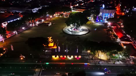 aerial view night shot of magelang town square. the city lights are bright and colorful. it says "magelang".