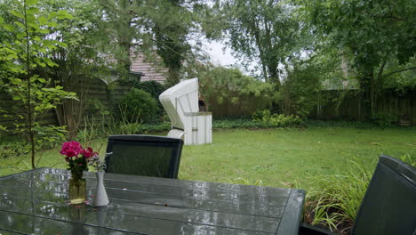 Wide-shot-of-a-white-beach-chair-standing-in-a-garden