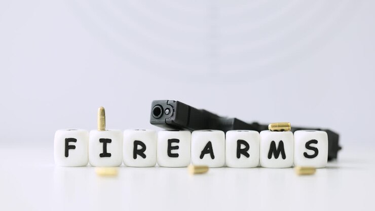 A pistol and bullets with the word firearms written out