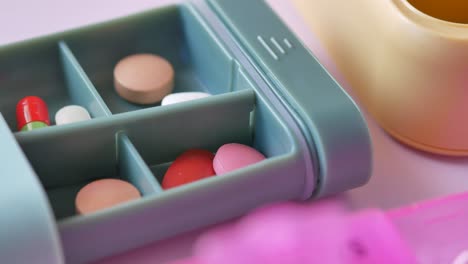 close up of medical pills in a pill box on table