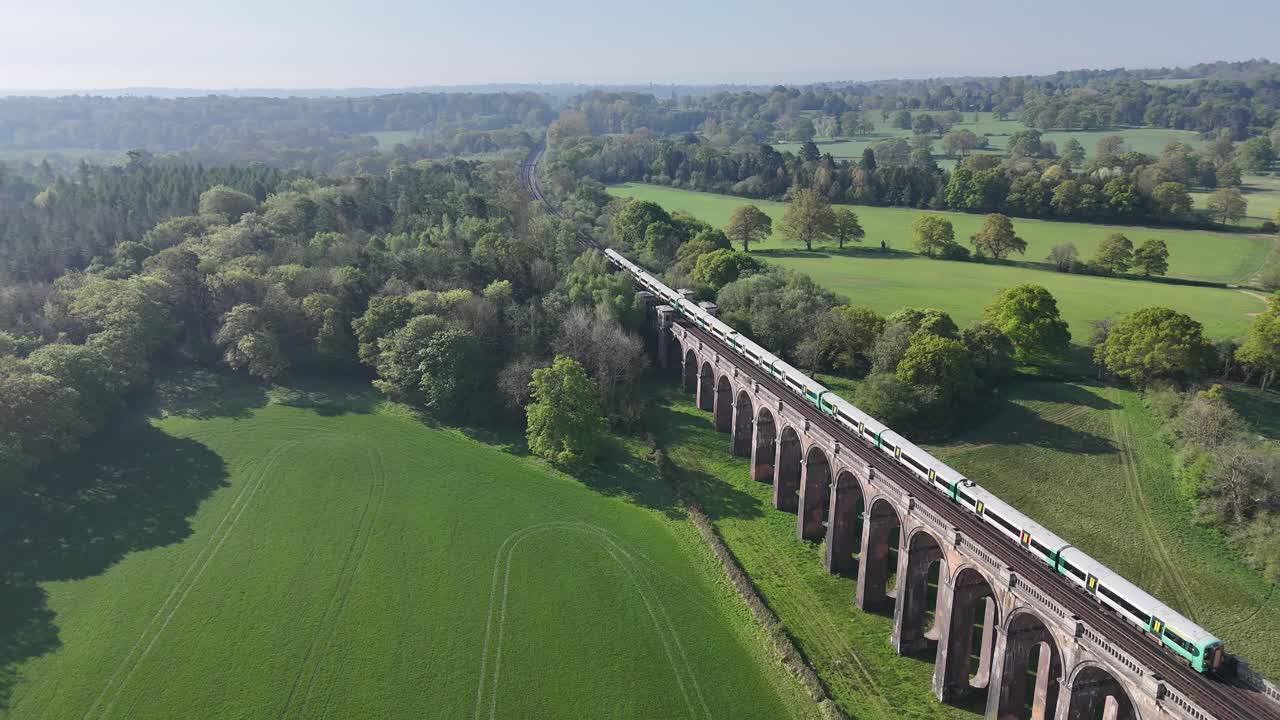 Smooth footage of a train crossing the Ouse Valley Viaduct (Balcombe Viaduct). Iconic Victorian architecture, dynamic motion. Ideal for transportation, travel, and historic projects.