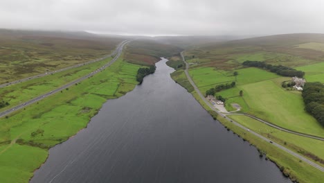 booth wood reservoir aerial view following the freshwater lake alongside the m62 motorway in west yorkshire