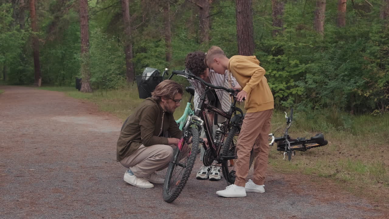 Man Fixing Bike On Family Walk