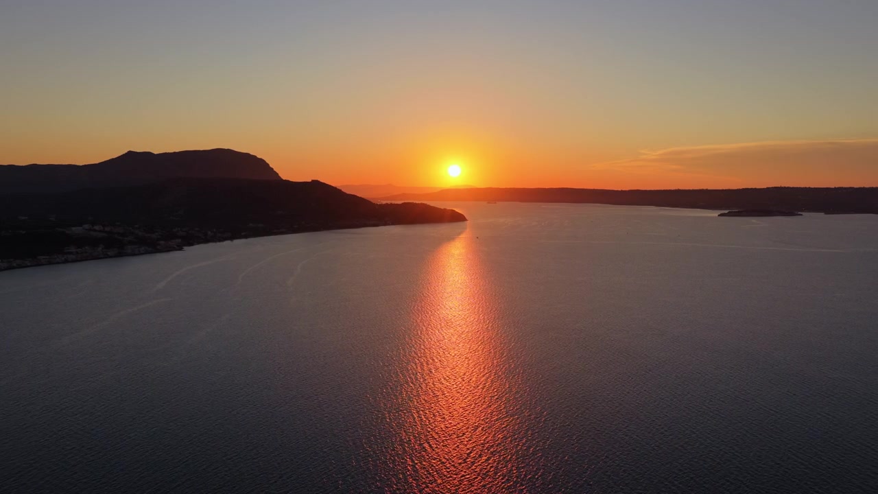 Dronekuva auringonlaskusta Hanian (Kreikka) suuren, tummien niemien rajaaman lahden kapeaan suuaukkoon.