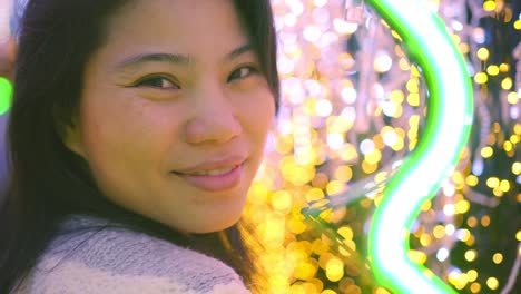 close-up asian happiness female face smiling with joy and cheerful surround with bokeh christmas decorative light christmas festive seasonal background concept