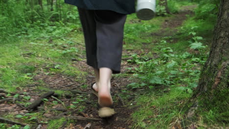 mujer caminando por un camino del bosque