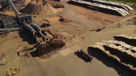 Aerial-view-of-Truck-transporting-wooden-trunks-and-driving-in-paper-mill-factory---Fray-Bentos,Uruguay