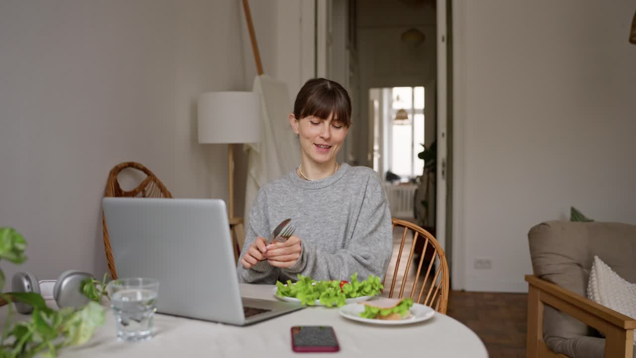 Woman having lunch while on a video call