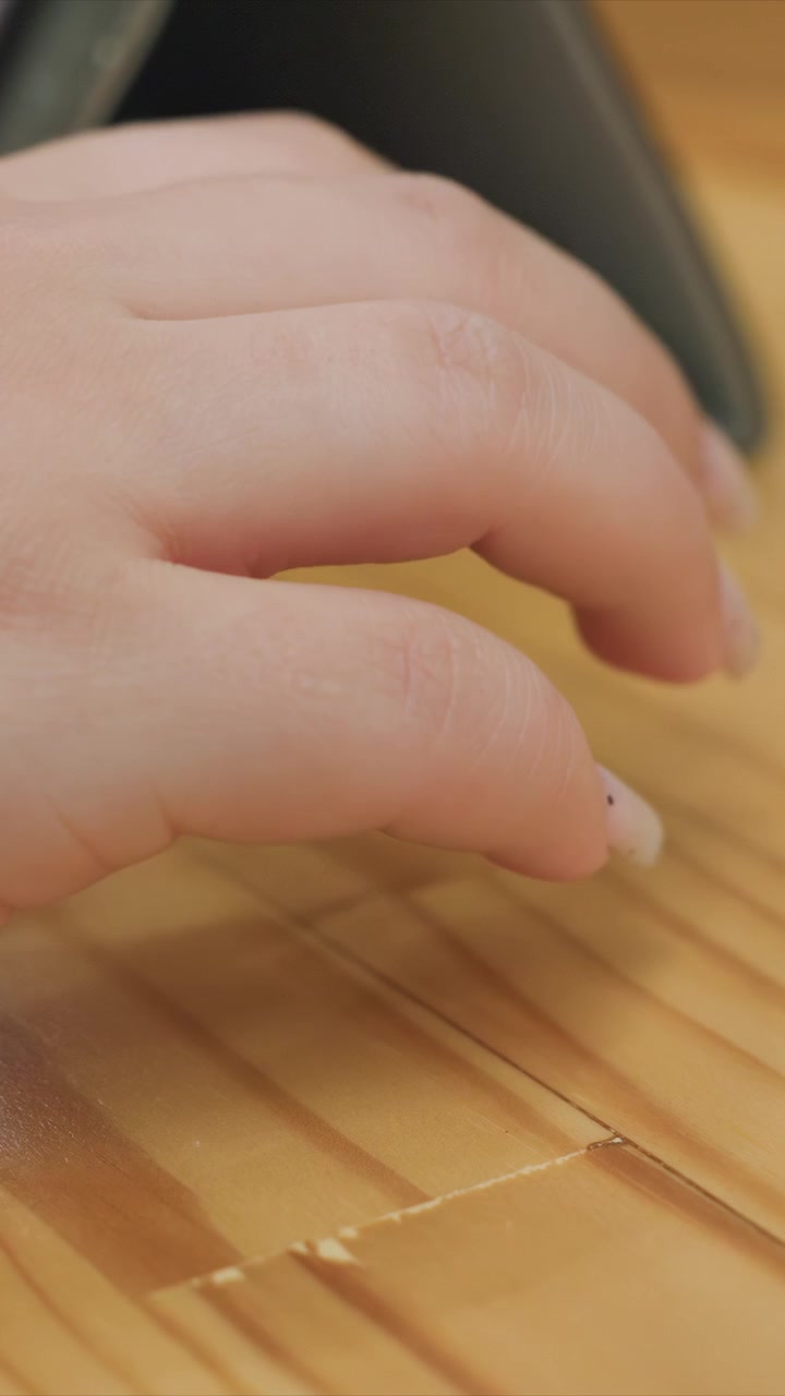 Craftsmanship visible as thread interlaces with grains. Detailed craftsmanship highlights texture integration. Indoor setting with focused lighting on hands and materials