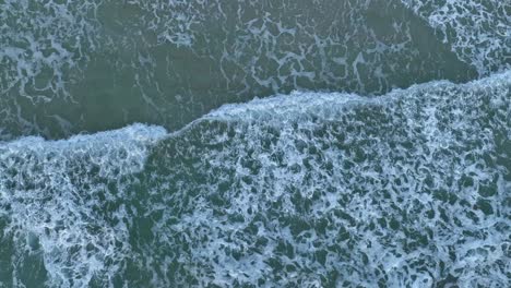 waves slowly rolling into beach