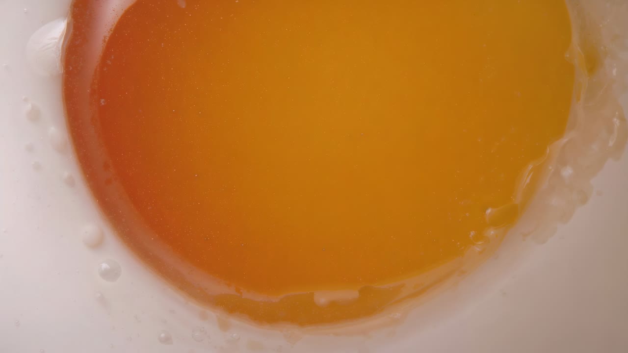 Widening camera revealing centered fried egg on white plate at kitchen counter, showing bubbles