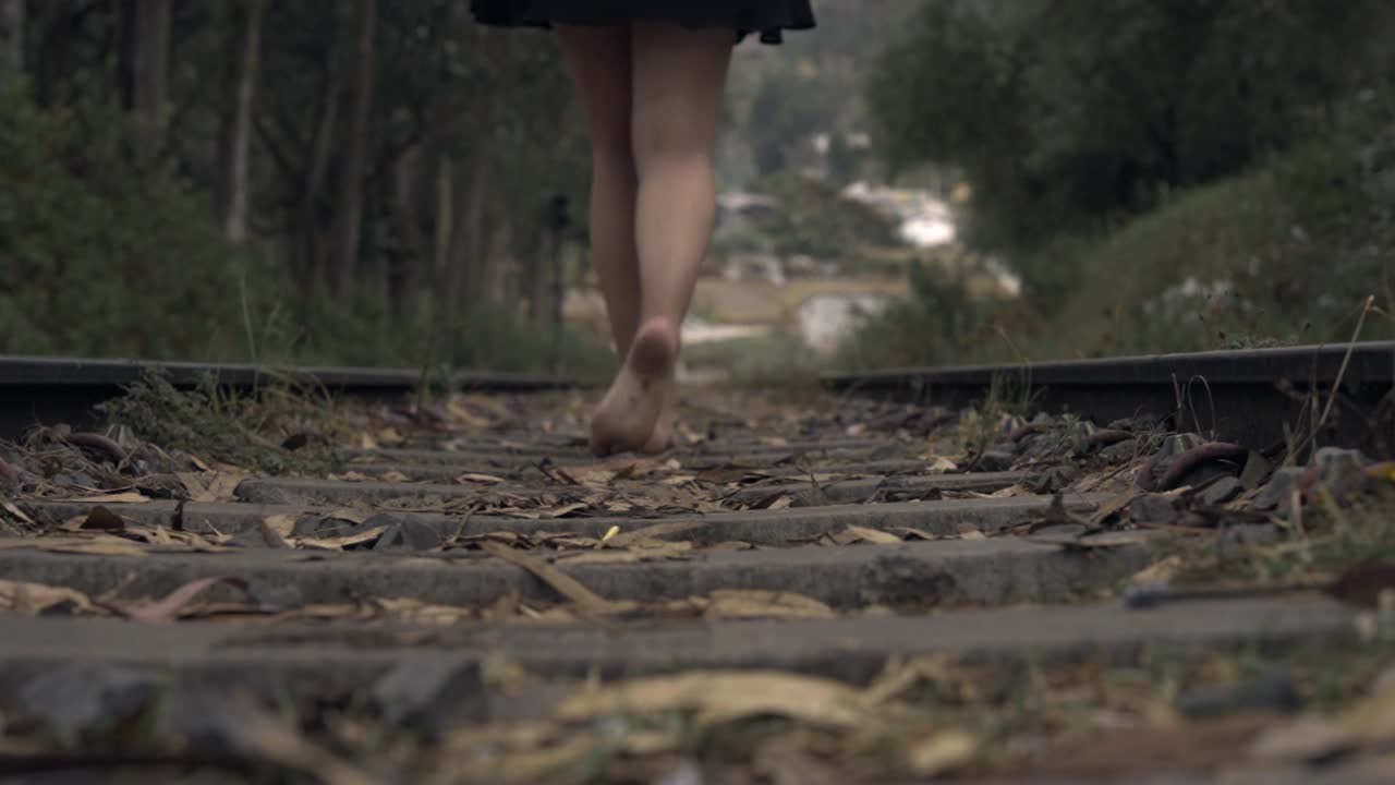 기차 레일 위를 고 있는 소녀