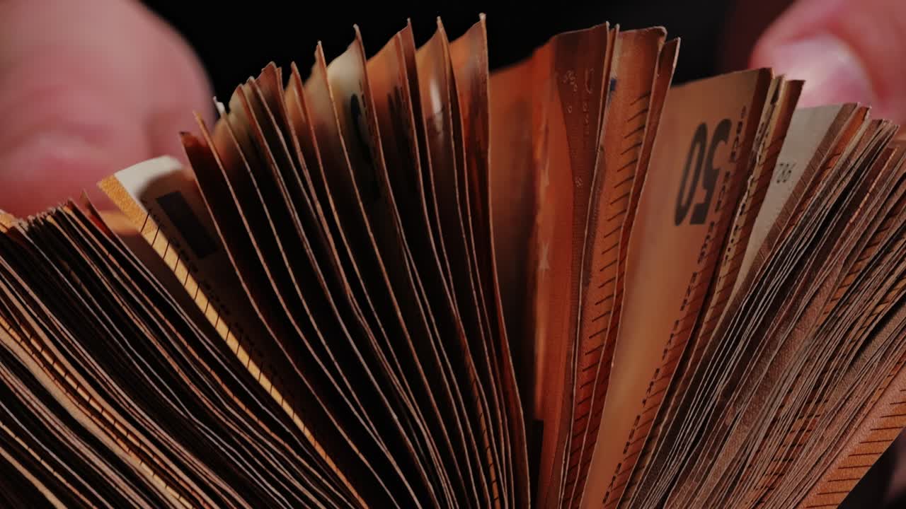 Dark cinematic shot of euro money opened in hands reveals value contradictions