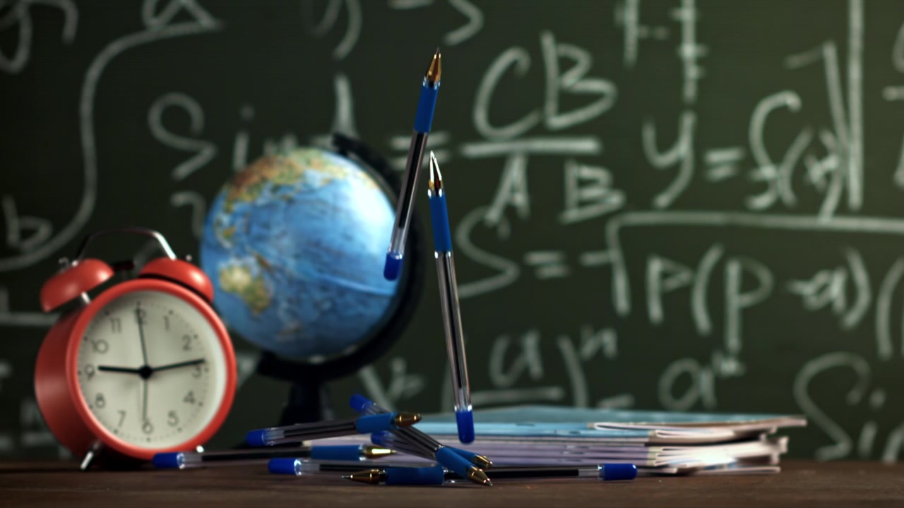 Pulpen Biru Jatuh dalam Gerakan Lambat di Atas Meja Kelas